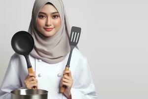 ai generado un asiático hembra cocinero en un hijab participación un espátula en un blanco antecedentes foto
