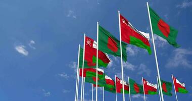 Oman et bangladesh drapeaux agitant ensemble dans le ciel, sans couture boucle dans vent, espace sur la gauche côté pour conception ou information, 3d le rendu video