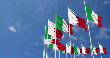 Bahreïn et Italie drapeaux agitant ensemble dans le ciel, sans couture boucle dans vent, espace sur la gauche côté pour conception ou information, 3d le rendu video