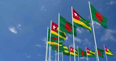 Togo and Bangladesh Flags Waving Together in the Sky, Seamless Loop in Wind, Space on Left Side for Design or Information, 3D Rendering video