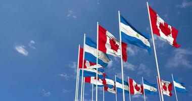 Nicaragua y Canadá banderas ondulación juntos en el cielo, sin costura lazo en viento, espacio en izquierda lado para diseño o información, 3d representación video