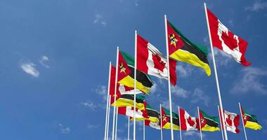 Mozambique and Canada Flags Waving Together in the Sky, Seamless Loop in Wind, Space on Left Side for Design or Information, 3D Rendering video