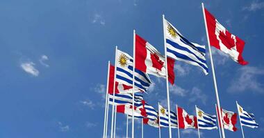 Uruguay and Canada Flags Waving Together in the Sky, Seamless Loop in Wind, Space on Left Side for Design or Information, 3D Rendering video