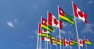 Togo and Canada Flags Waving Together in the Sky, Seamless Loop in Wind, Space on Left Side for Design or Information, 3D Rendering video