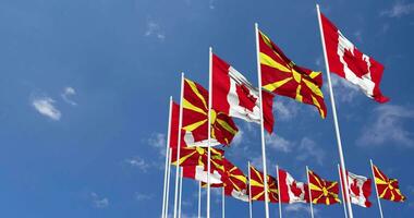 Norden Mazedonien und Kanada Flaggen winken zusammen im das Himmel, nahtlos Schleife im Wind, Raum auf links Seite zum Design oder Information, 3d Rendern video