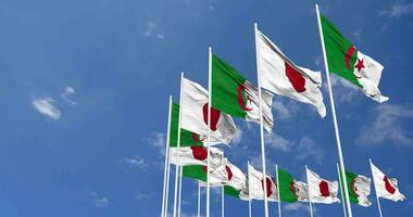 Algeria and Japan Flags Waving Together in the Sky, Seamless Loop in Wind, Space on Left Side for Design or Information, 3D Rendering video