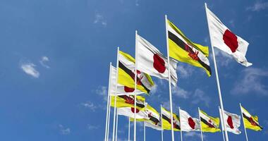 brunei e Giappone bandiere agitando insieme nel il cielo, senza soluzione di continuità ciclo continuo nel vento, spazio su sinistra lato per design o informazione, 3d interpretazione video