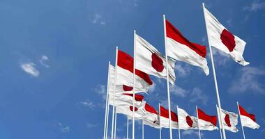 Indonésia e Japão bandeiras acenando juntos dentro a céu, desatado ciclo dentro vento, espaço em esquerda lado para Projeto ou Informação, 3d Renderização video