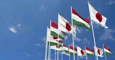 Ungarn und Japan Flaggen winken zusammen im das Himmel, nahtlos Schleife im Wind, Raum auf links Seite zum Design oder Information, 3d Rendern video