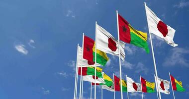 Guinea bissau e Giappone bandiere agitando insieme nel il cielo, senza soluzione di continuità ciclo continuo nel vento, spazio su sinistra lato per design o informazione, 3d interpretazione video