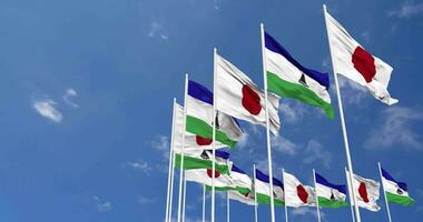 Lesotho and Japan Flags Waving Together in the Sky, Seamless Loop in Wind, Space on Left Side for Design or Information, 3D Rendering video