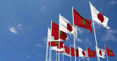 Marocco e Giappone bandiere agitando insieme nel il cielo, senza soluzione di continuità ciclo continuo nel vento, spazio su sinistra lato per design o informazione, 3d interpretazione video