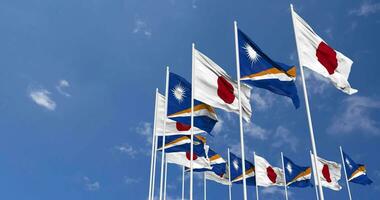marshall öar och japan flaggor vinka tillsammans i de himmel, sömlös slinga i vind, Plats på vänster sida för design eller information, 3d tolkning video