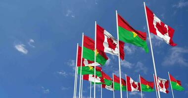 burkina faso et Canada drapeaux agitant ensemble dans le ciel, sans couture boucle dans vent, espace sur la gauche côté pour conception ou information, 3d le rendu video