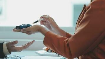 Insurance officers hand over the car keys after the tenant. have signed an auto insurance document or a lease or agreement document Buying or selling a new or used car with a car video