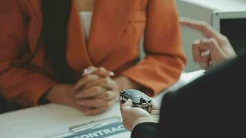 Insurance officers hand over the car keys after the tenant. have signed an auto insurance document or a lease or agreement document Buying or selling a new or used car with a car video