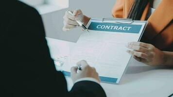 Salesman guiding customer seated at table Car business Dealership closing. and the new owner has entered into a contract video