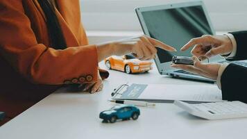 Salesman guiding customer seated at table Car business Dealership closing. and the new owner has entered into a contract video