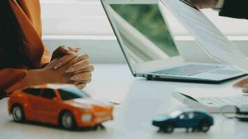 Salesman guiding customer seated at table Car business Dealership closing. and the new owner has entered into a contract video