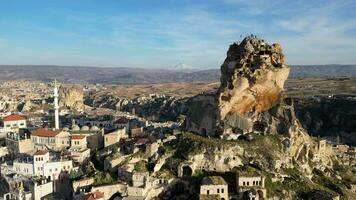 Aerial drone view of the Ortahisar Castle in Cappadocia, Turkey with the snow capped Mount Erciyes in the background. People enjoying the view from the top of the castle. video