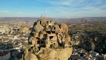 aéreo zumbido ver de el ortahisar castillo en capadocia, Turquía con el nieve tapado montar erciyes en el antecedentes. personas disfrutando el ver desde el parte superior de el castillo. video