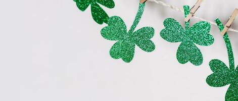 Green glitter shamrocks homemade garland. Happy St. Patricks Day background, banner format photo