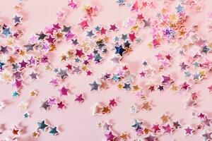 Multicolor holographic Stars Glitter Confetti on pink background. Festive backdrop, selective focus photo