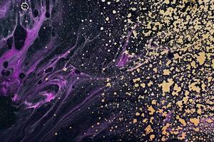 Fluid Art. Metallic gold spray and purple waves. Marble effect background or texture photo