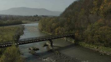 alt Eisenbahn Brücke Über ein Fluss. Drohne Flug Über Brücke von alt eng Spur Eisenbahn video