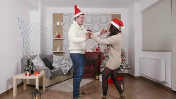 Happy dancing couple enjoying Christmas eve together, slow motion video