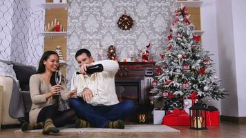 Lycklig caucasian par dricka champagne i jul dekorerad rum, långsam rörelse skott video