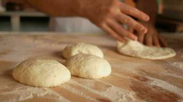 hands form pieces of dough for baking bread and rolls. video