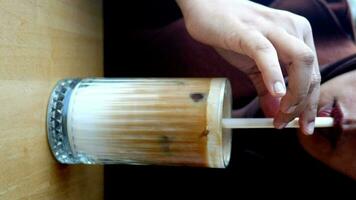 women drinking iced late in a transparent glass on cafe table outdoor video