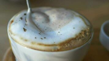 person hand stirring coffee with spoon. video