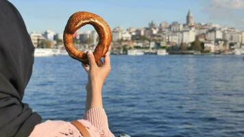 kvinnor innehav en turkiska bagel simit mot istanbul stad bakgrund video