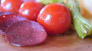 salami sausage, tomato and capsicum on wooden table video