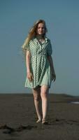 Sensual female model in summer dress and barefoot walking along beach of black sand on Pacific Coast video