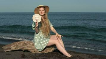 Smiling young woman holds mirror in her hand and closes herself with other hand from sun's rays video