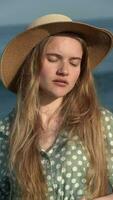 Sensual woman with eyes closed. Blonde female in straw hat and summer light green polka dot dress video