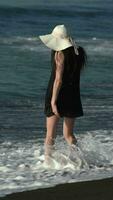 irreconocible mujer entra en rotura olas de Pacífico Oceano durante verano playa fiesta video