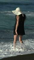 Unrecognizable woman enters in breaking waves of Pacific Ocean during summer beach holiday video