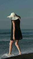 onherkenbaar blootsvoets vrouw wandelen Aan zwart zanderig strand Aan grote Oceaan oceaan, zomer strand vakantie video