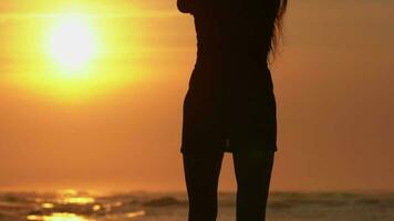 Rear view silhouette unrecognizable sensuality woman in summer short dress walking beach at sunrise video