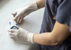 Close up shot of the glucometer instrument on the white surface. Healthcare photo