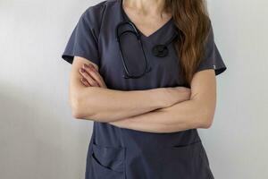 Shot of the female doctor in uniform against the white wall. Healthcare photo