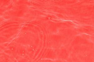 Redwater splashes on the surface ripple blur. Defocus blurred transparent purple colored clear calm water surface texture with splash and bubble. photo