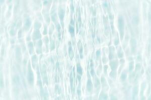 Defocus blurred transparent blue colored clear calm water surface texture with splashes and bubbles. Trendy abstract nature background. Water waves in sunlight with copy space. Blue watercolor shining photo