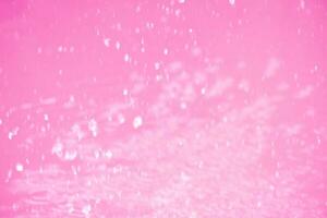 Purple water waves on the surface ripples blur. Defocus blurred transparent pink colored clear calm water surface texture with splash and bubbles. Water waves with shining pattern texture background. photo