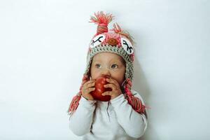 Little girl biting a red apple photo