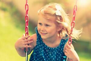 Little girl on a swing photo